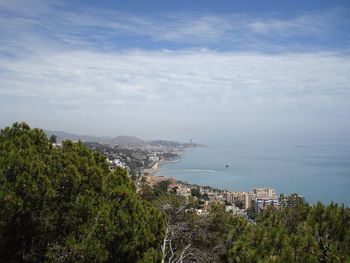 High angle view of city by sea against sky