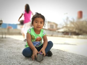 Portrait of cute girl sitting outdoors