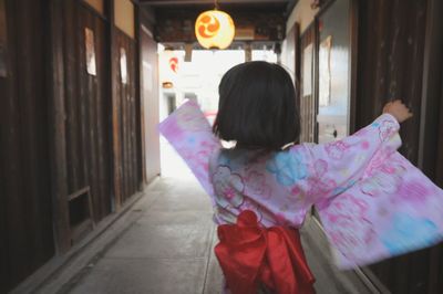 Rear view of girl standing in corridor