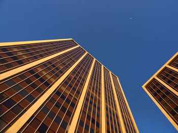 Low angle view of modern building against clear blue sky