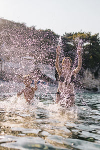 Man splashing water against sky