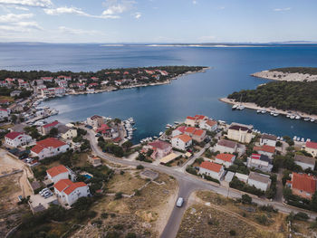 High angle view of townscape by sea against sky