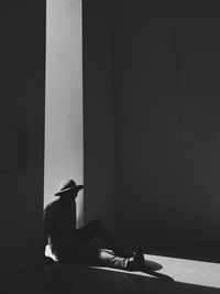 Young man sitting on floor at doorway