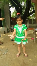 Girl playing with stick while standing at park