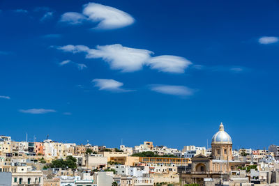 Buildings in city against blue sky