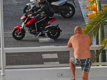 Rear view of shirtless man standing on street