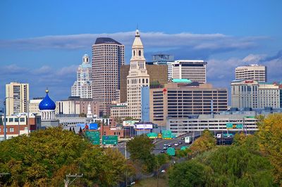 View of buildings in city against cloudy sky