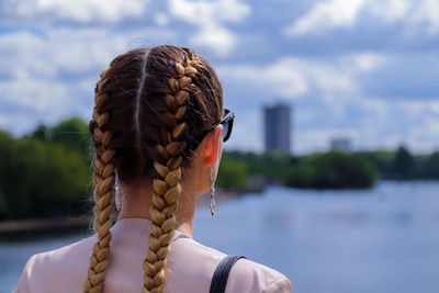 Rear view of woman with rope against sky