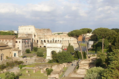 Aerial panoramic cityscape view of the roman forum and roman colosseum during sunset in rome, italy