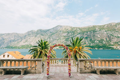 Palm trees by sea against sky