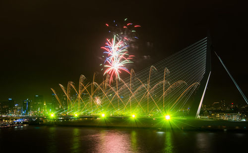 Firework exploding over erasmus bridge at night