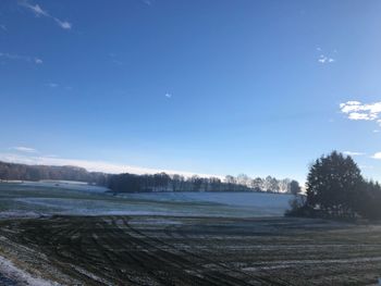 Scenic view of landscape against blue sky during winter