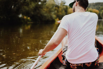 Rear view of man canoeing in lake