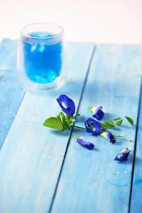 Close-up of blue flower in glass on table