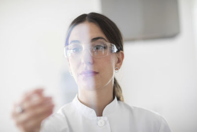 Scientist female with lab glasses, tablet and sample in a lab