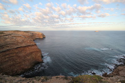 View of rocky coastal feature against calm sea