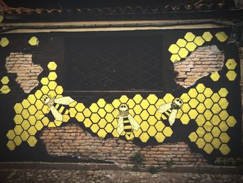 Close-up of yellow text on wall in illuminated building