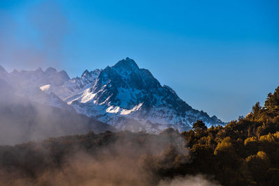 Scenic view of snowcapped mountains against blue sky