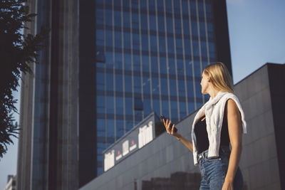 Young woman standing against building