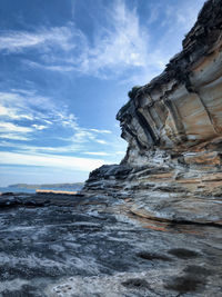 Rock formations by sea against sky