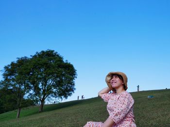 Woman standing on field against clear sky