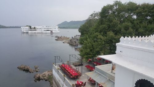 High angle view of taj lake palace from lake pichola against the sky.