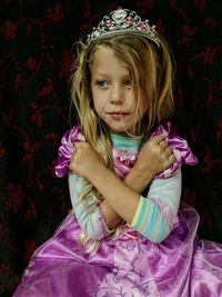 Girl wearing pink dress while standing against wall