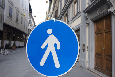 Close-up of road sign on street against buildings