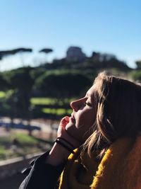 Close-up of woman with eyes closed against mountains