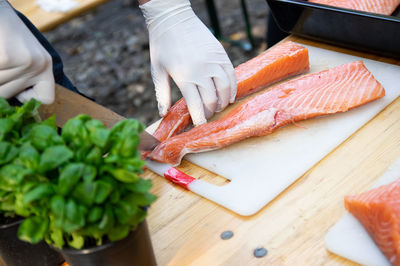 Midsection of person preparing food on cutting board