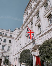 Low angle view of flags on building against sky