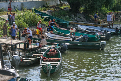 People on boat moored in river