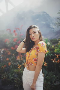 Beautiful woman standing by railing in park