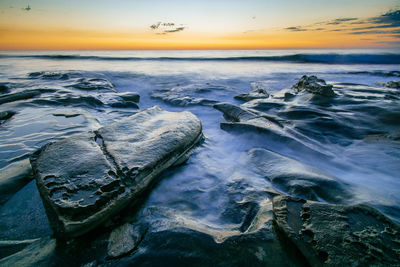 Close-up of sea against sky during sunset