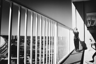 Full length of boy standing by railing at balcony