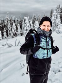 Portrait of woman standing on snow covered mountain