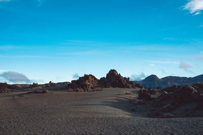 Scenic view of desert against blue sky