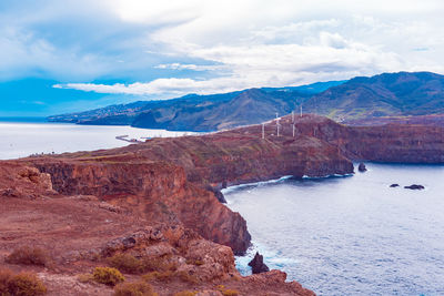 Scenic view of sea and mountains against sky