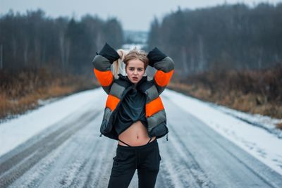 Portrait of woman standing on snowy road