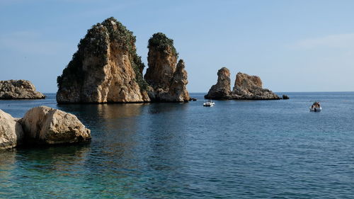 Rock formation in sea against sky