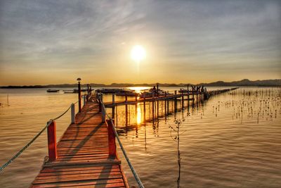 Pier over sea against sky during sunset