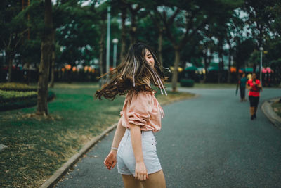 Girl standing by tree against plants