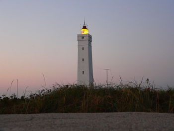 Lighthouse against sky at sunset