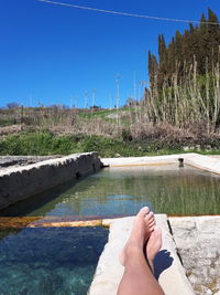 Low section of person against blue sky