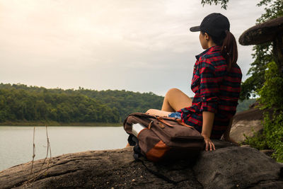 Woman standing on boat by lake against sky