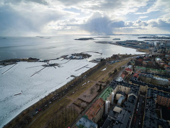 High angle view of city by sea against sky