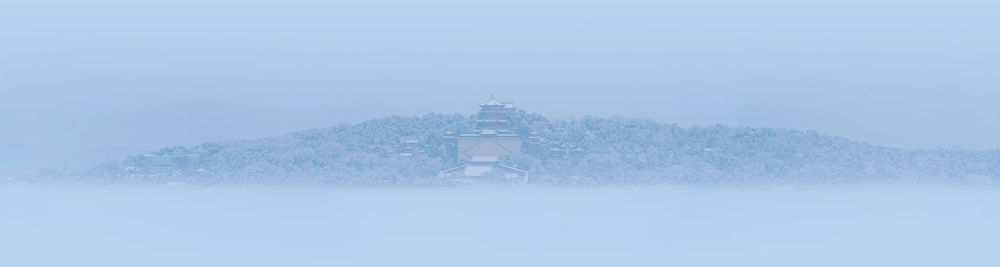 Snow covered trees and buildings against sky