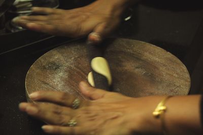 Close-up of man holding hands on table