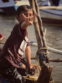Full length of shirtless man holding boat in water