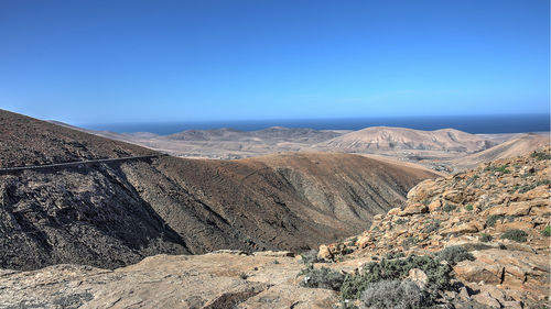 Scenic view of mountains against clear blue sky